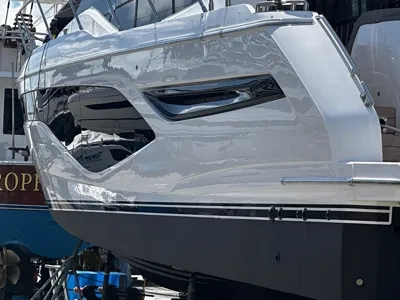 Polished white motor yacht topsides reflecting the dock