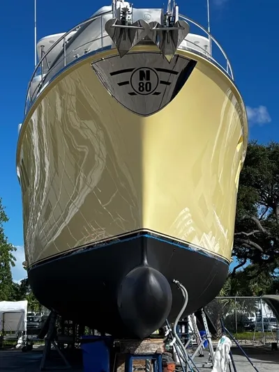 Cream hull of an N80 trawler, bow on, after a cut and polish